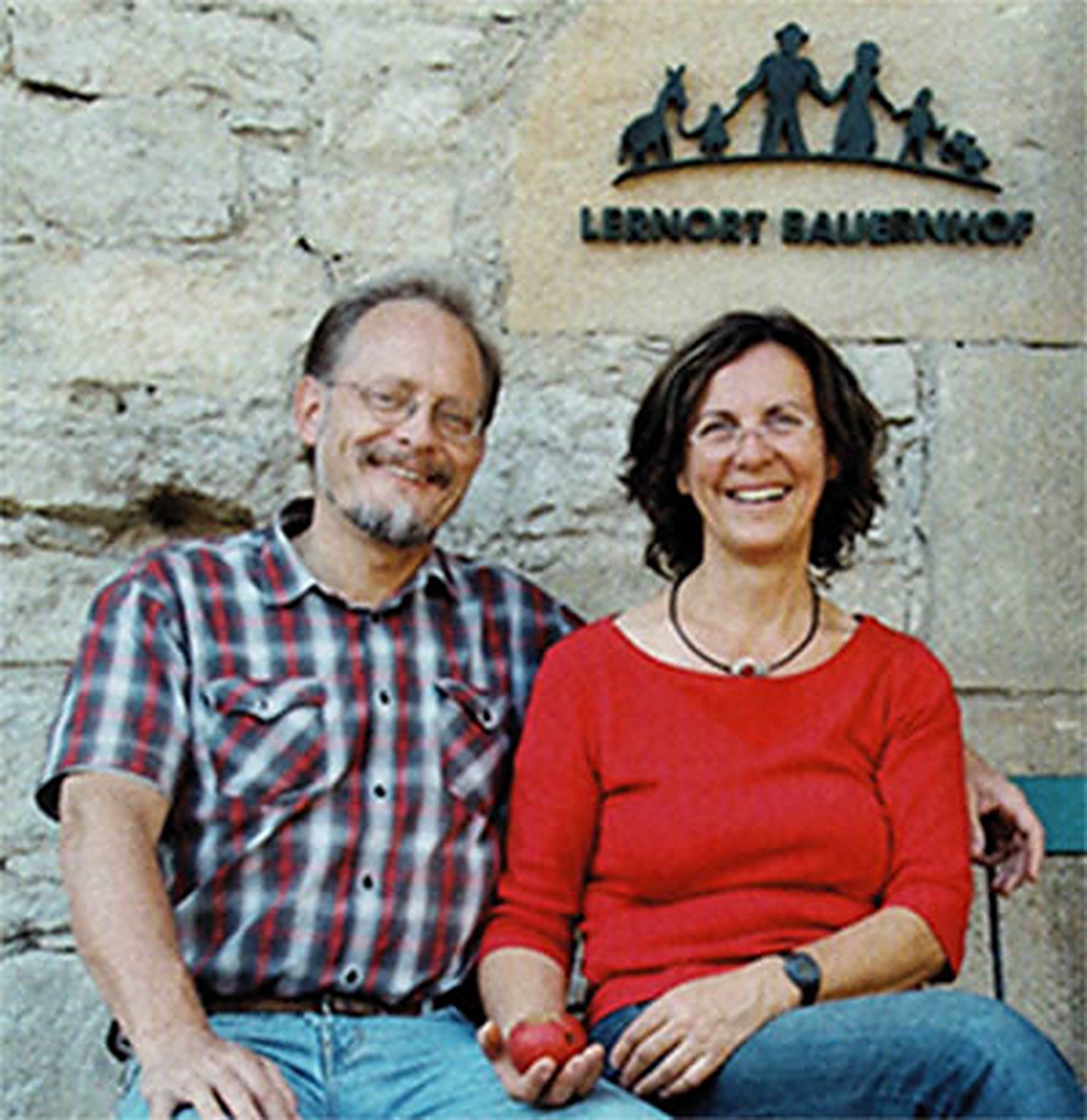 Zwei Personen vor dem Schild „Lernort Bauernhof“ am Pabst-Hof